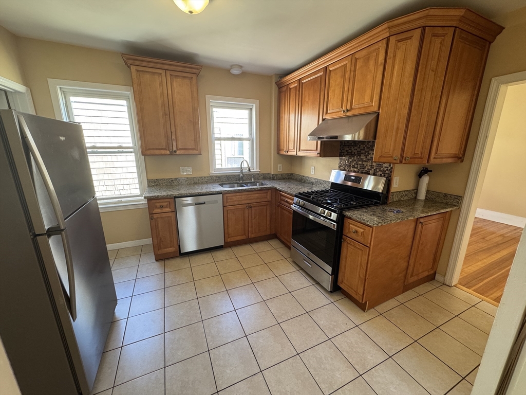 a kitchen with stainless steel appliances granite countertop a stove a sink and a refrigerator