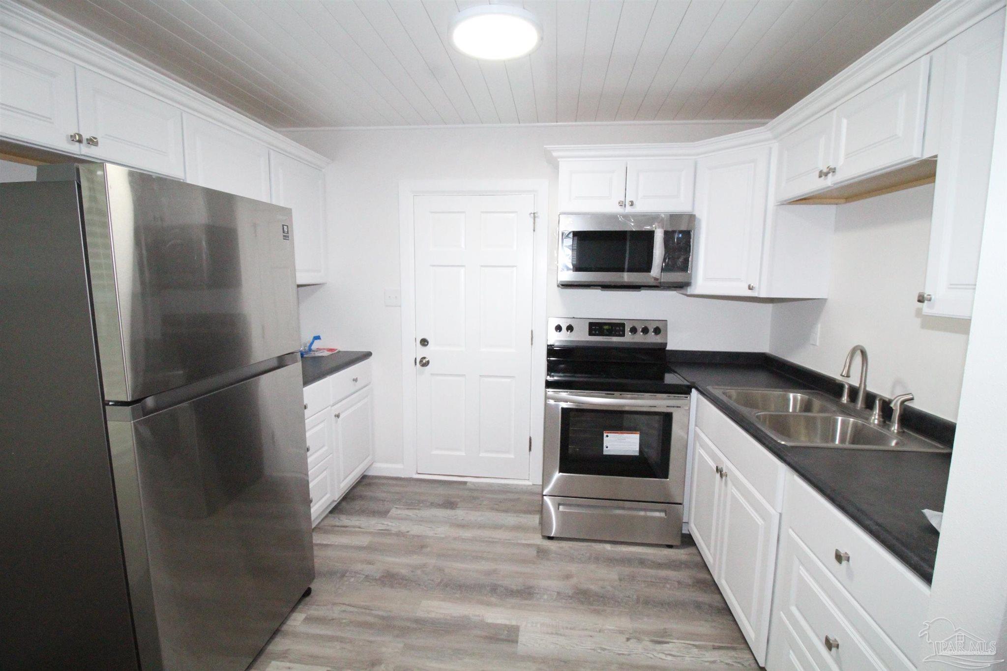 5523 Shell Street Pensacola, FL 32503 - Photo 4 of 11 a kitchen with a refrigerator stove and sink