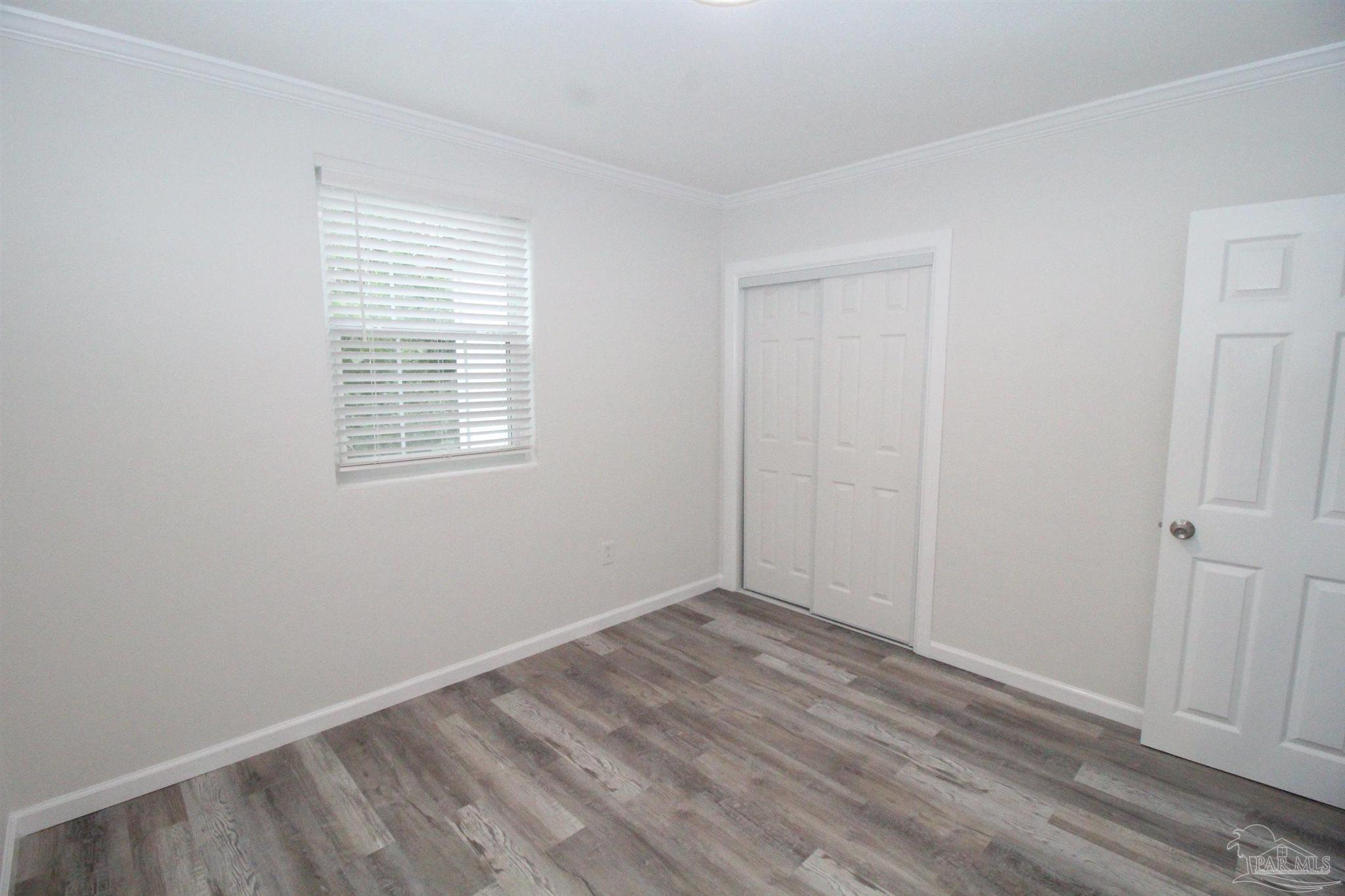 5523 Shell Street Pensacola, FL 32503 - Photo 6 of 11 an empty room with wooden floor and windows