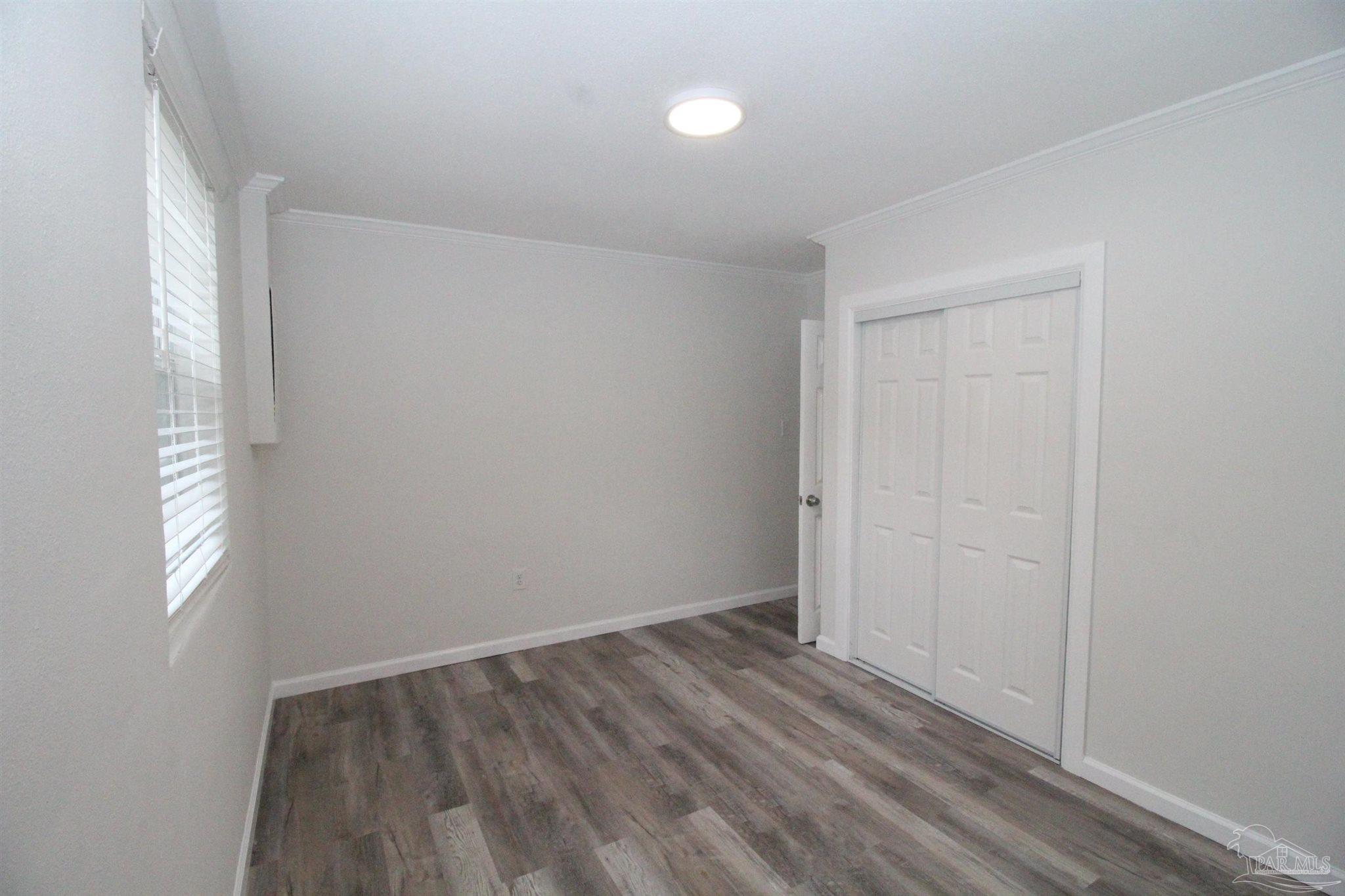 5523 Shell Street Pensacola, FL 32503 - Photo 9 of 11 an empty room with wooden floor and windows