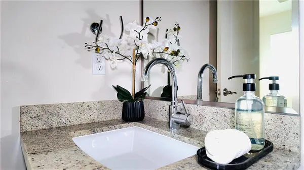 a bathroom with a granite countertop sink and a mirror