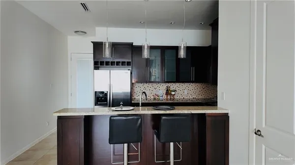 a kitchen with stainless steel appliances granite countertop a refrigerator and a sink