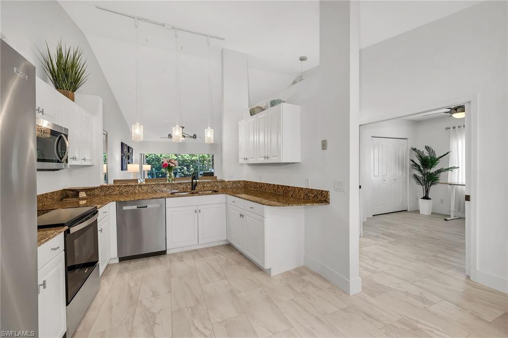 1747 Reuven Circle, Unit 4 Naples, FL 34112 - Photo 12 of 46 a large kitchen with cabinets and wooden floor