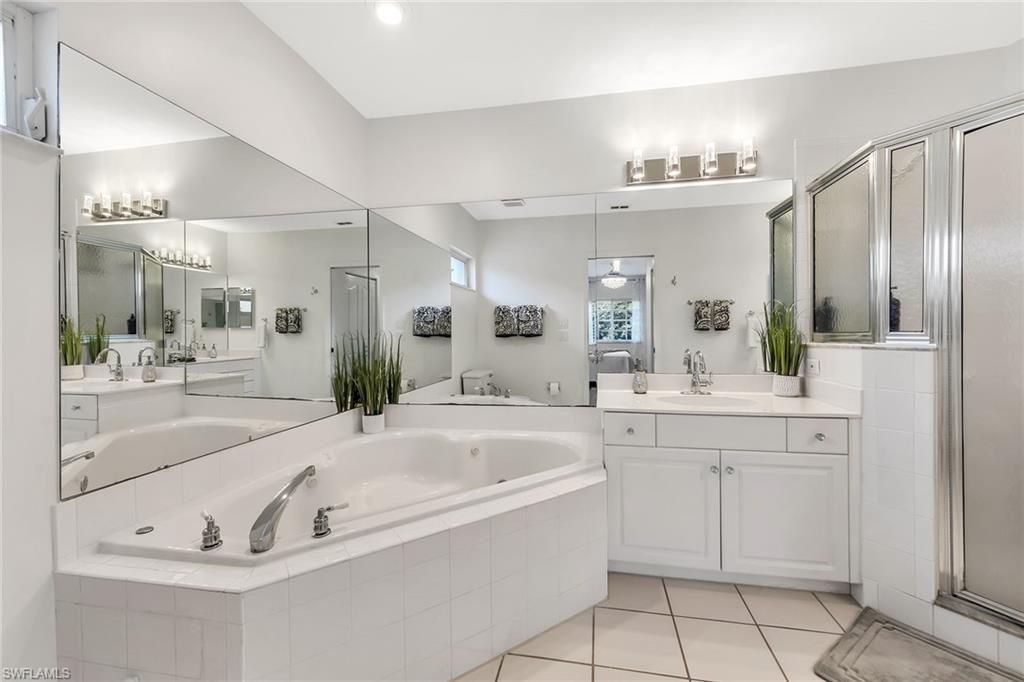 1747 Reuven Circle, Unit 4 Naples, FL 34112 - Photo 19 of 46 a large spacious bathroom with a tub sink and mirror
