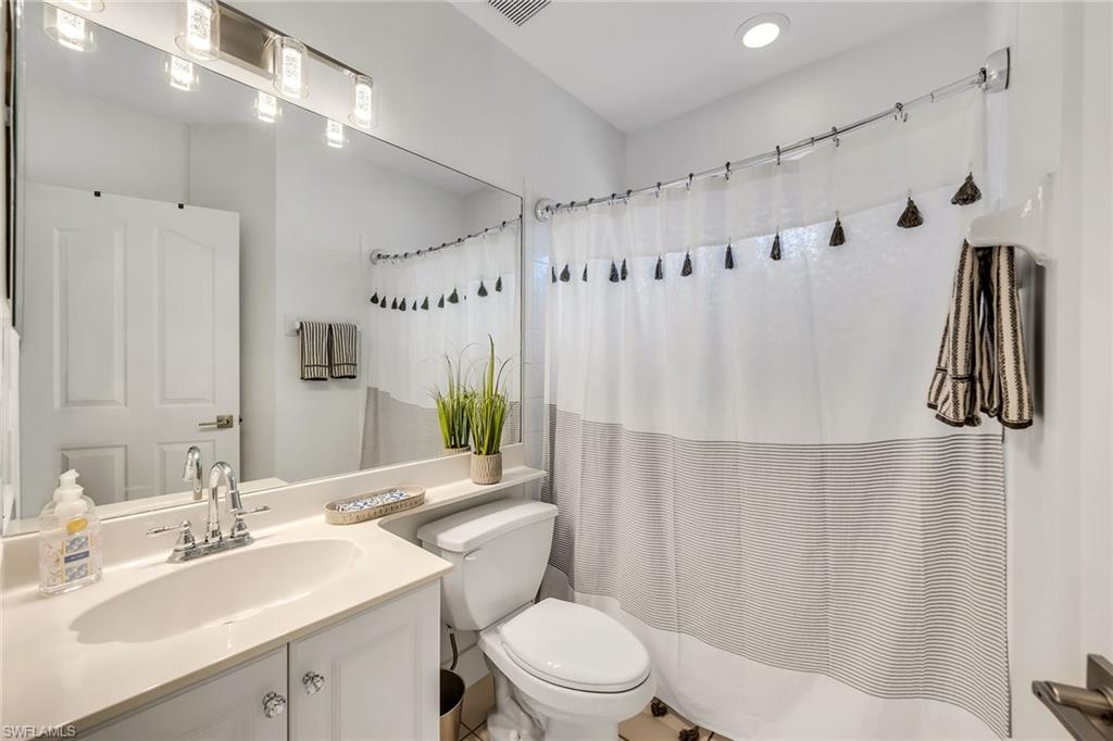 1747 Reuven Circle, Unit 4 Naples, FL 34112 - Photo 25 of 46 a bathroom with a sink vanity mirror and toilet