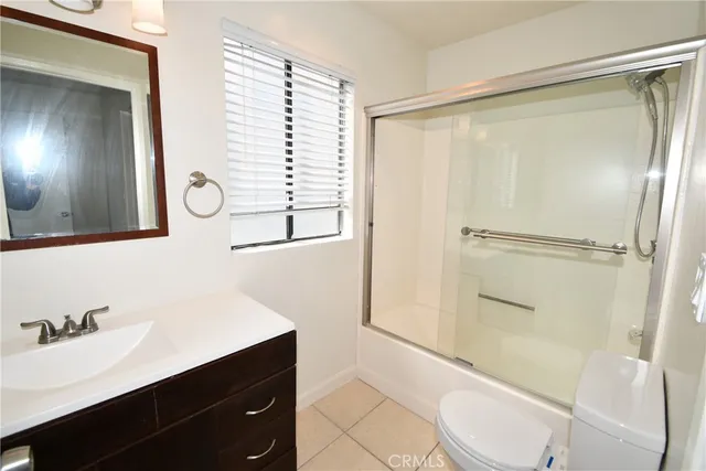 a bathroom with a sink a toilet a mirror and shower