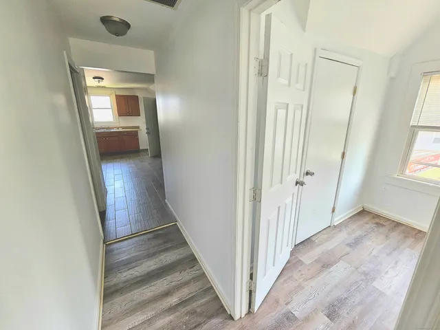 a view of a hallway with wooden floor and stairs