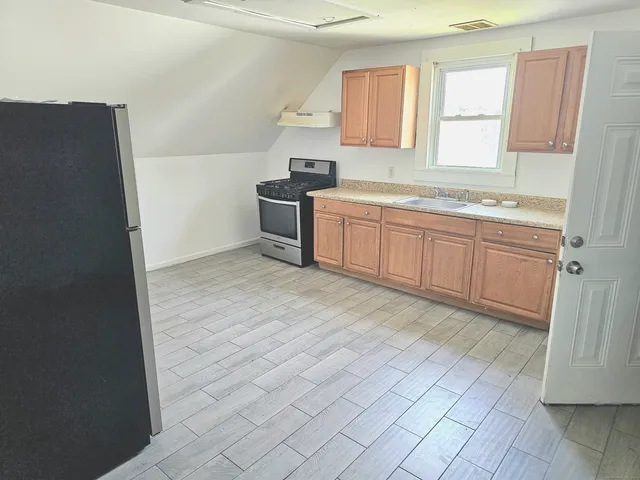 a spacious bathroom with a granite countertop sink a mirror and a bathtub
