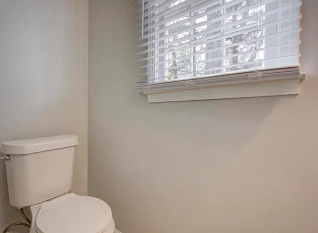 a white toilet sitting next to a window
