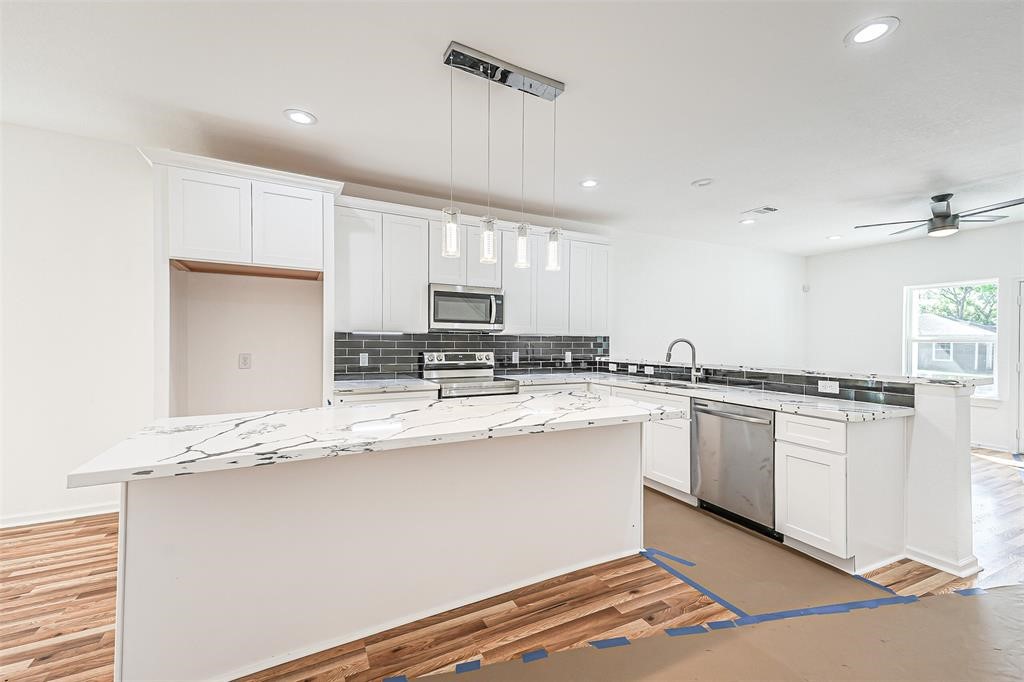 5317 Chennault Road, Unit A Houston, TX 77033 - Photo 6 of 11 a kitchen with stainless steel appliances granite countertop a sink and a stove