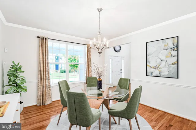 a dining room with furniture a large window and wooden floor