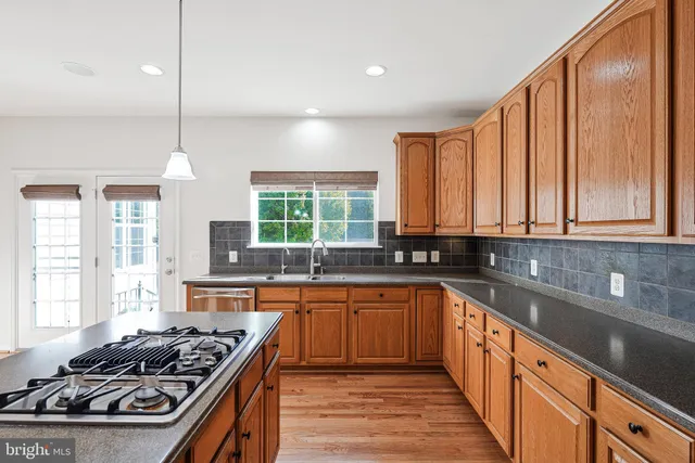 a kitchen with stainless steel appliances a sink stove and cabinets