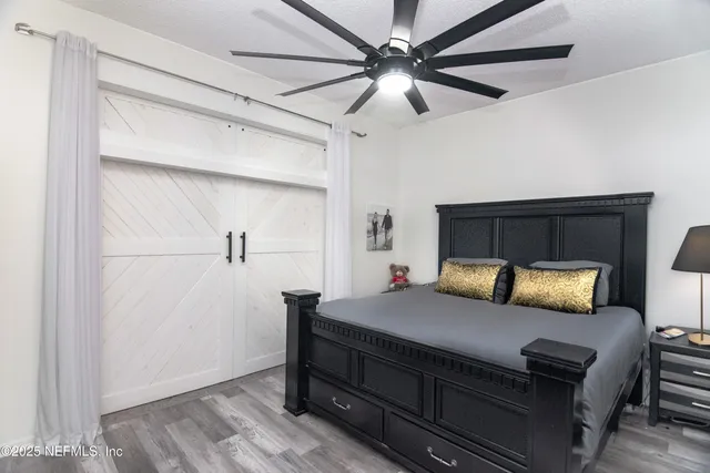 a bedroom with a bed and a ceiling fan
