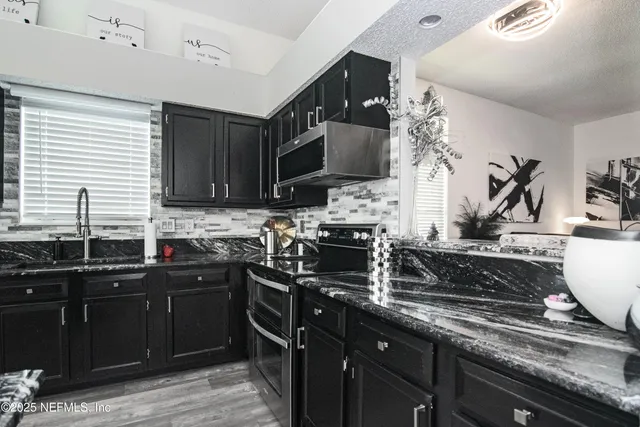 a kitchen with stainless steel appliances a sink stove and microwave