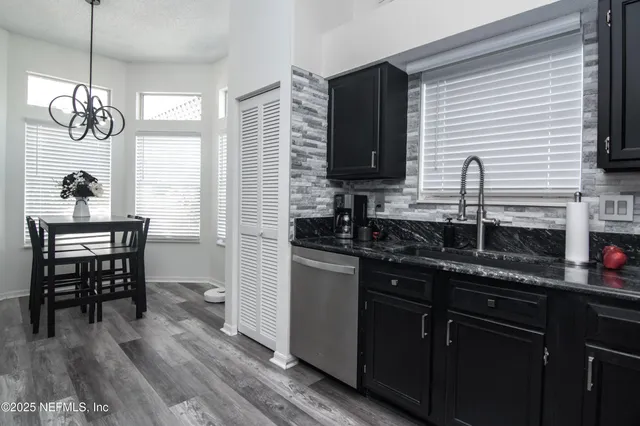 a kitchen with granite countertop a sink stainless steel appliances and cabinets
