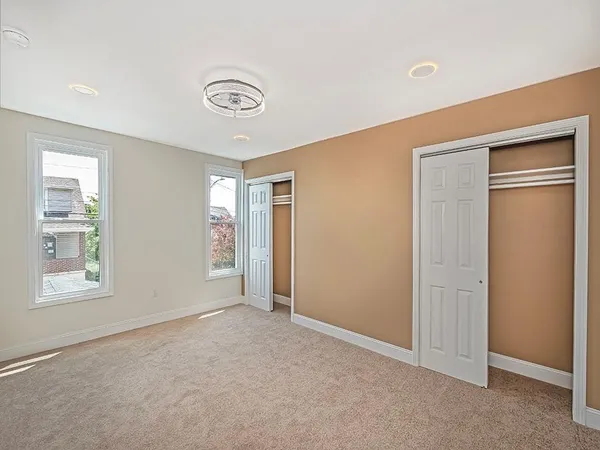 an empty room with windows and closet