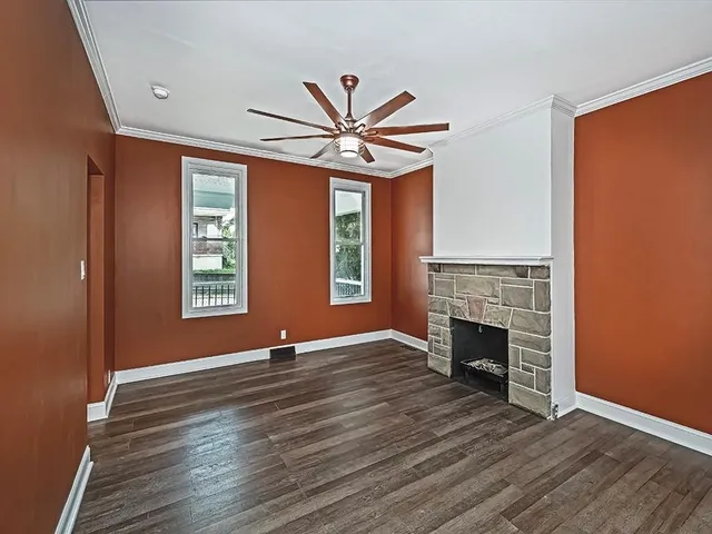 a view of an empty room with window and wooden floor