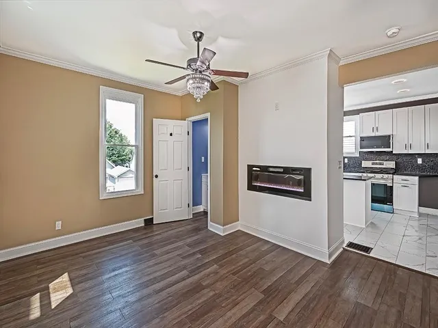 a view of an empty room with a window and wooden floor