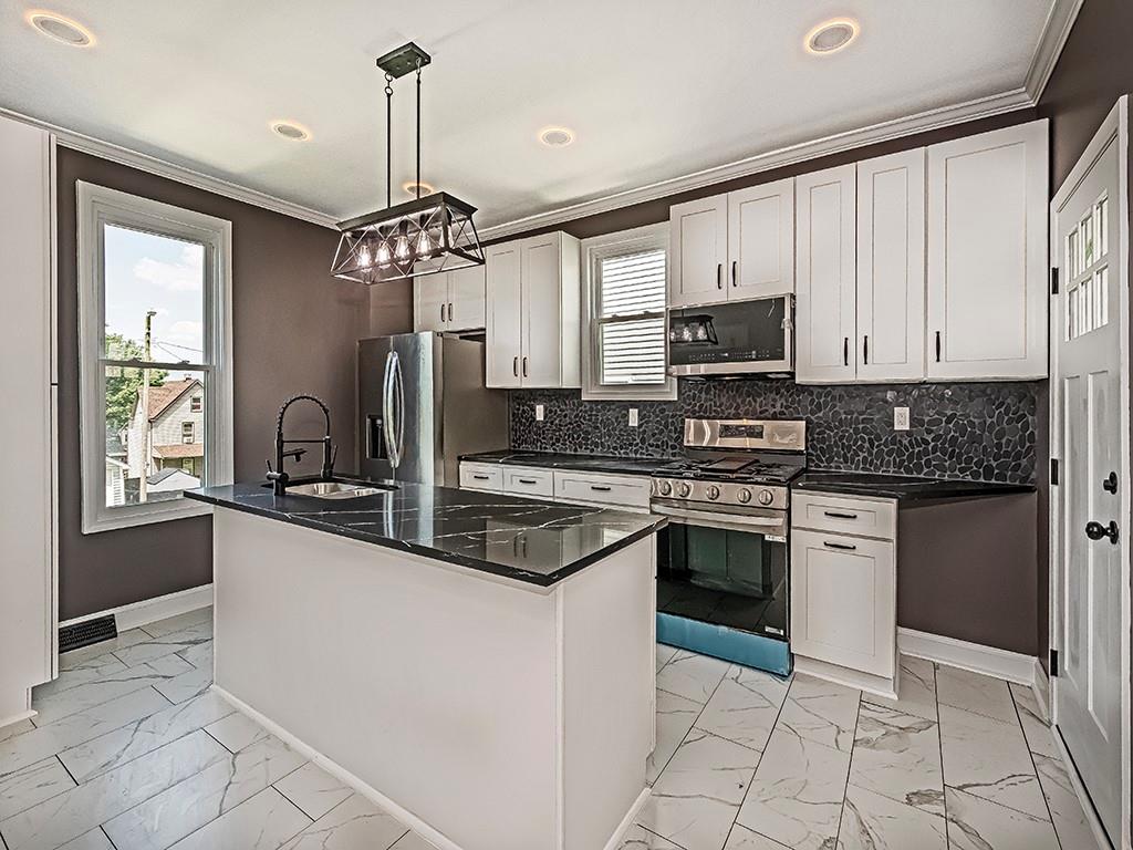 1741 Freeport Road New Kensington, PA 15068 - Photo 9 of 28 a kitchen with stainless steel appliances granite countertop a stove sink and cabinets