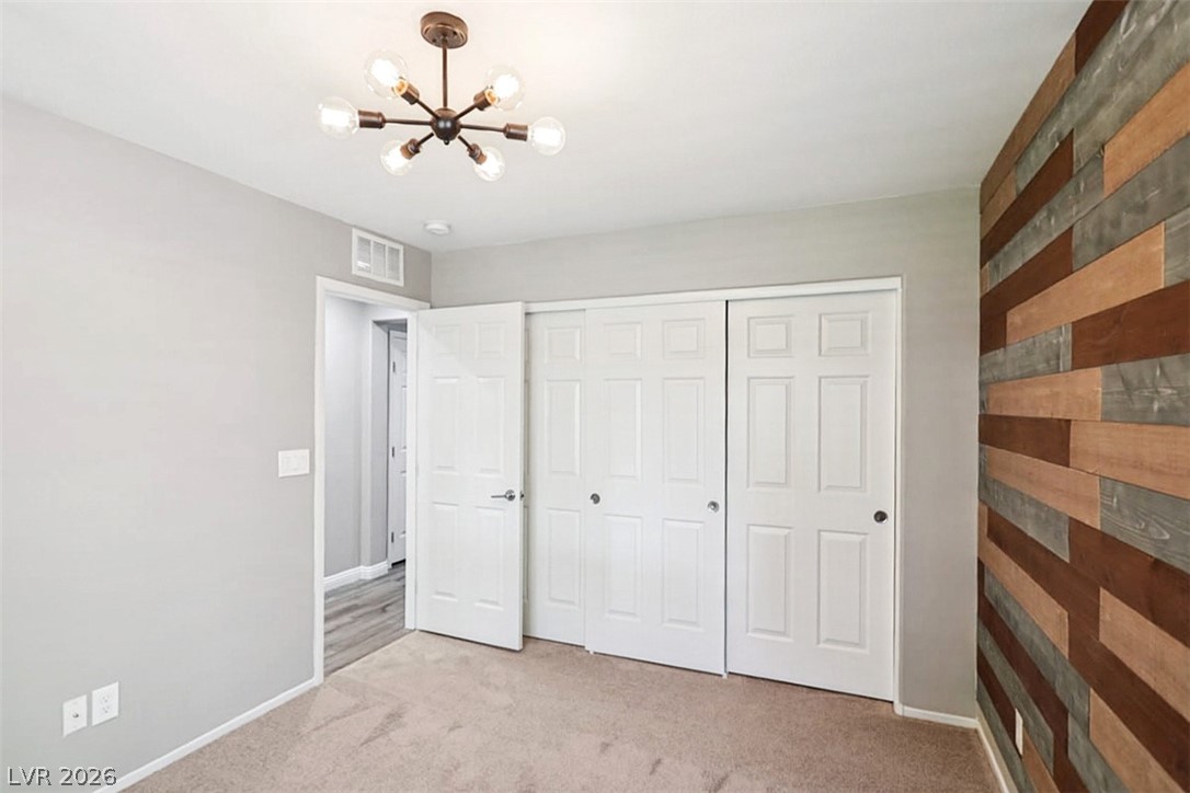 9940 Sable Point Street Las Vegas, NV 89178 - Photo 14 of 40 Unfurnished bedroom with a chandelier, carpet flooring, a closet, and baseboards