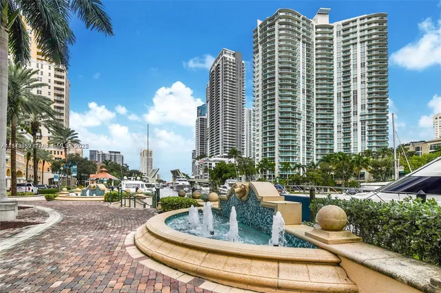 a sign board with a house and trees in the background