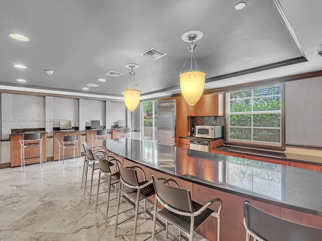 a kitchen with stainless steel appliances granite countertop a stove top oven a sink dishwasher a dining table and chairs with wooden floor