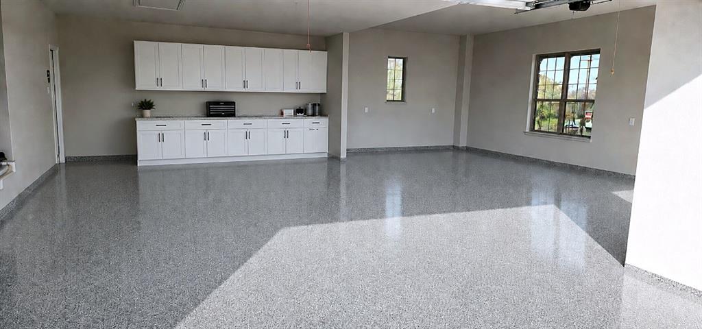 25 Morrison Road Howe, TX 75459 - Photo 24 of 27 Spacious garage featuring a speckled epoxy floor, white shaker-style cabinetry with ample storage, a light-toned countertop, and multiple windows