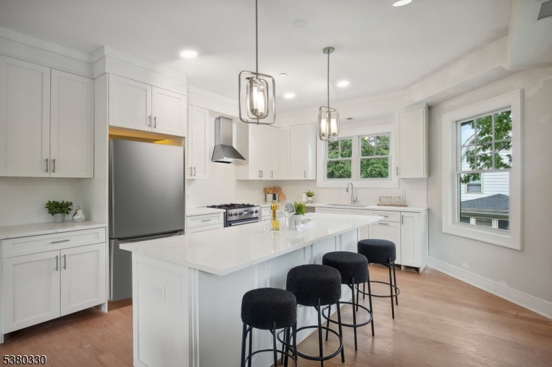 603 Springfield Avenue, Unit 104 Summit, NJ 07901 - Photo 4 of 6 a kitchen with refrigerator cabinets dining table and chairs
