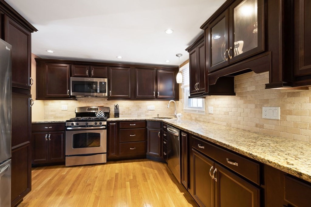 22 Kennedy Road Sharon, MA 02067 - Photo 11 of 41 a kitchen with stainless steel appliances granite countertop a stove sink microwave and cabinets