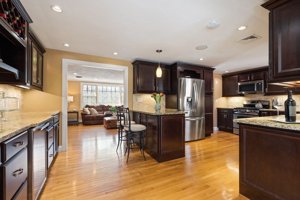 22 Kennedy Road Sharon, MA 02067 - Photo 15 of 41 a kitchen with stainless steel appliances granite countertop a refrigerator a stove top oven a sink dishwasher and wooden cabinets with wooden floor