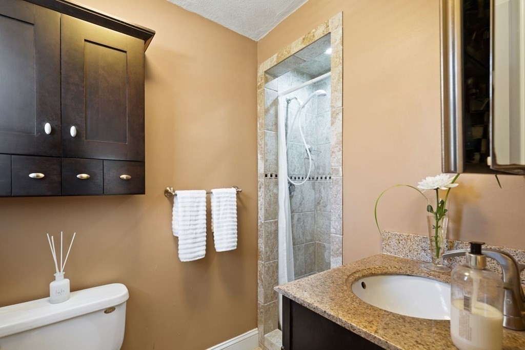 22 Kennedy Road Sharon, MA 02067 - Photo 19 of 41 a bathroom with a granite countertop sink a toilet a mirror and vanity