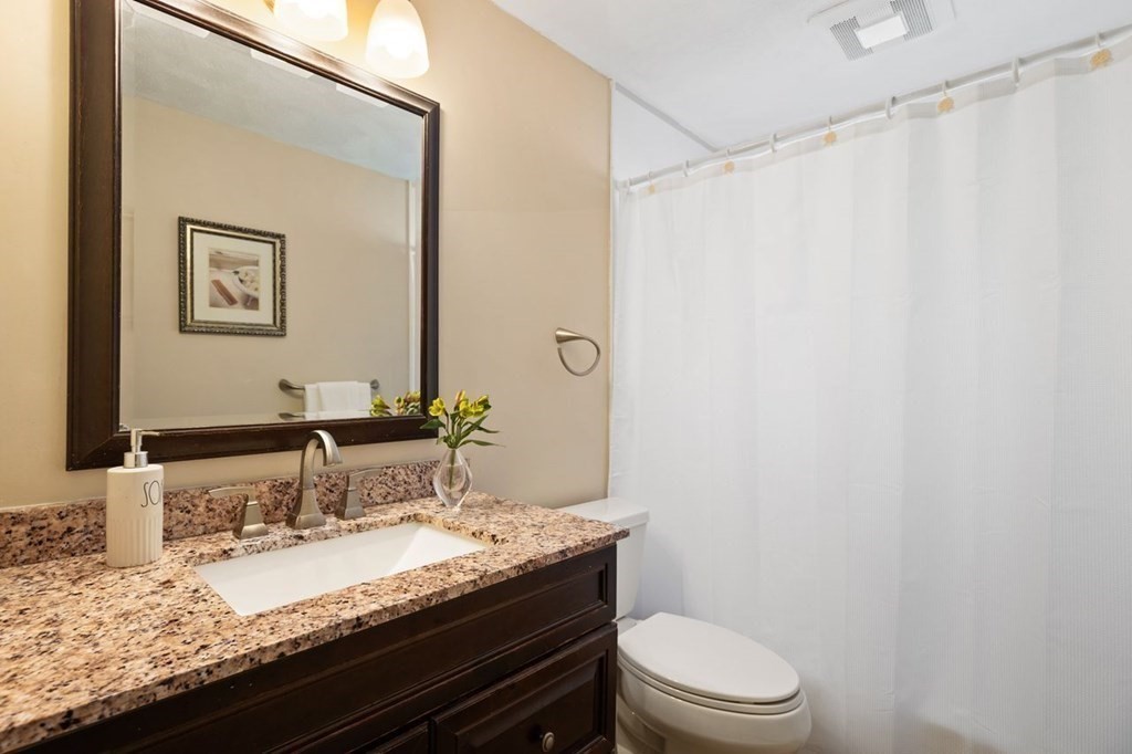 22 Kennedy Road Sharon, MA 02067 - Photo 21 of 41 a bathroom with a granite countertop sink a toilet and a mirror