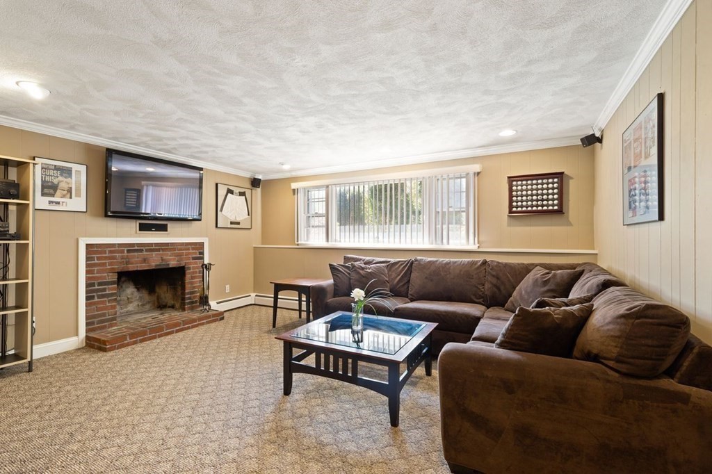 22 Kennedy Road Sharon, MA 02067 - Photo 25 of 41 a living room with furniture a flat screen tv and a fireplace