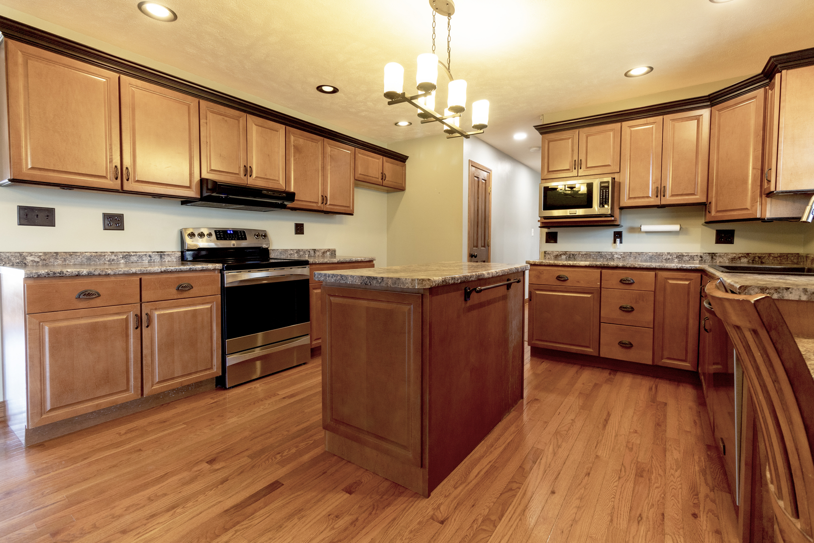 1455 North Gorham Road Morris, IL 60450 - Photo 7 of 22 a kitchen with stainless steel appliances granite countertop wooden floors a stove top oven a sink dishwasher and cabinets with wooden floor