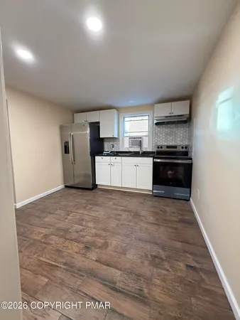 a large kitchen with kitchen island granite countertop a stove and a refrigerator