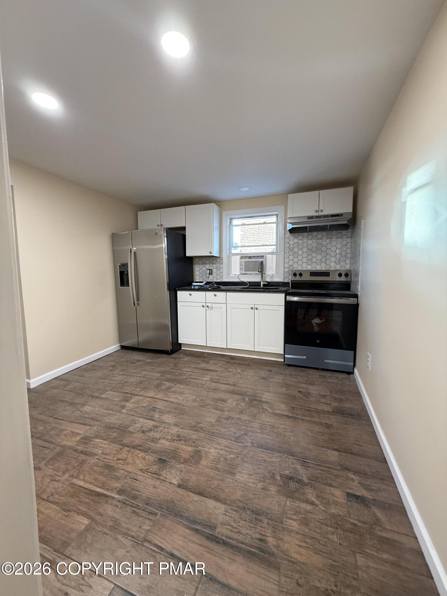526 Main Street, Unit 2 Stroudsburg, PA 18360 - Photo 6 of 9 a large kitchen with kitchen island granite countertop a stove and a refrigerator