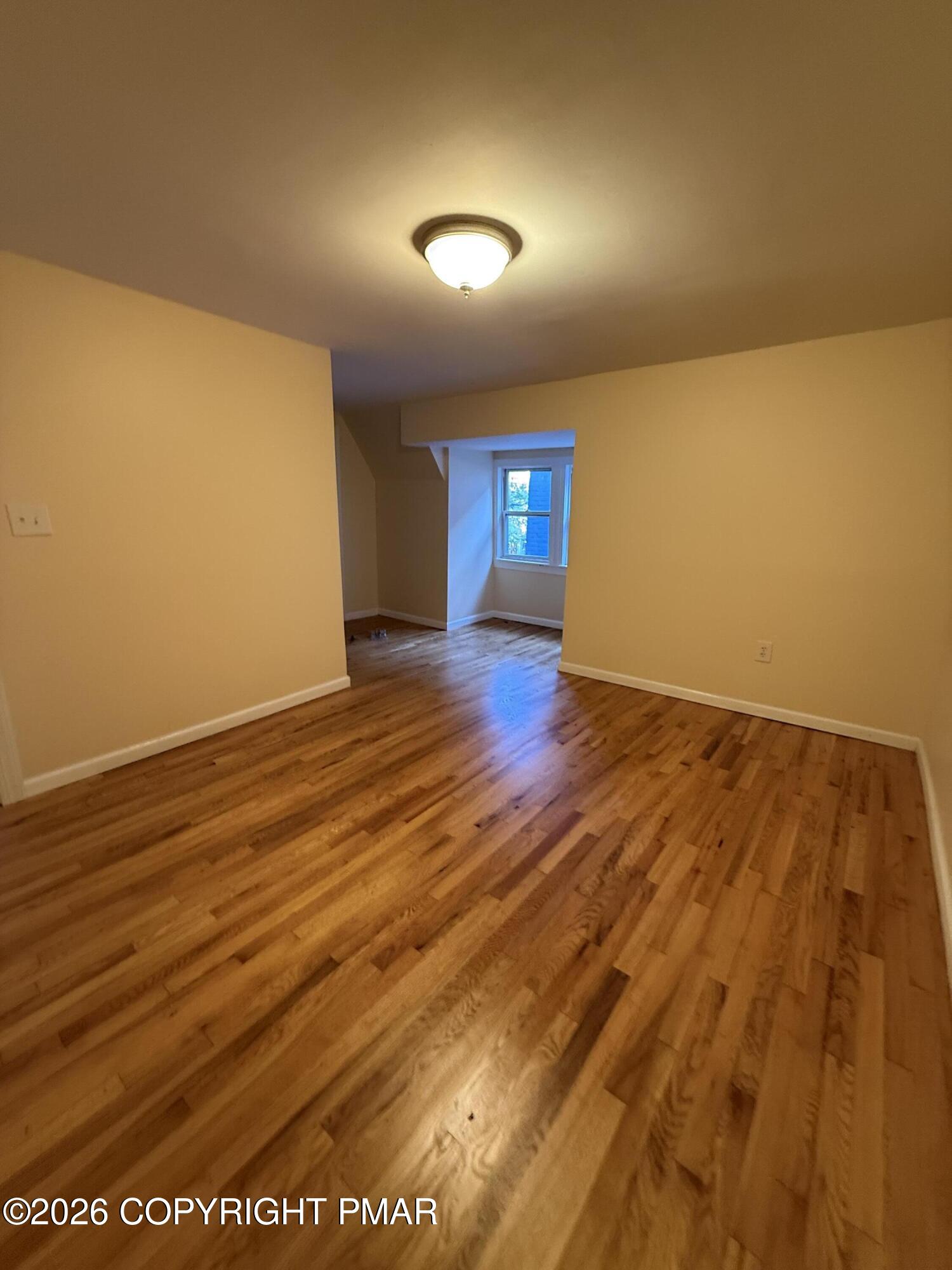 526 Main Street, Unit 2 Stroudsburg, PA 18360 - Photo 8 of 9 an empty room with wooden floor and windows