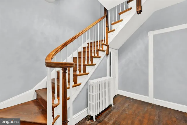 a view of staircase with wooden floor and white walls