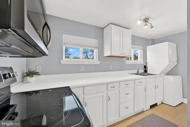 a kitchen with sink cabinets and a stove top oven