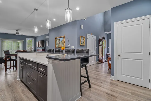 a kitchen with stainless steel appliances granite countertop a refrigerator a sink dishwasher and a stove with wooden floor