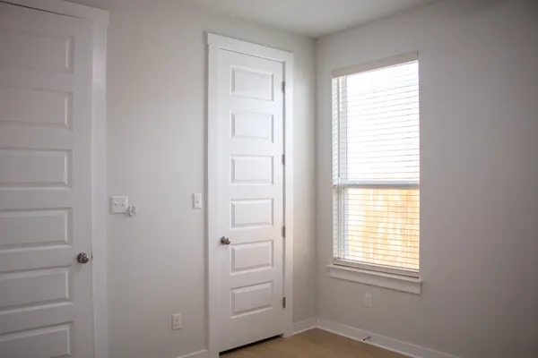 an empty room with windows and closet