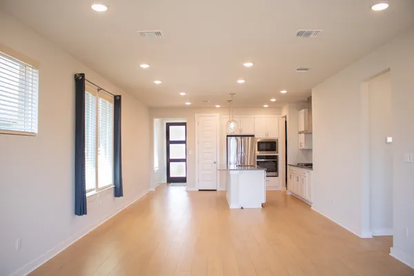 a view of a kitchen with refrigerator and wooden floor