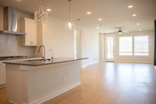 a view of a kitchen with a sink and wooden floor