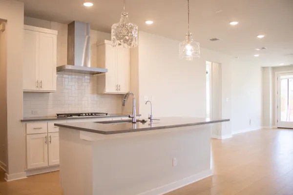 a kitchen with stainless steel appliances granite countertop a sink a stove and a refrigerator