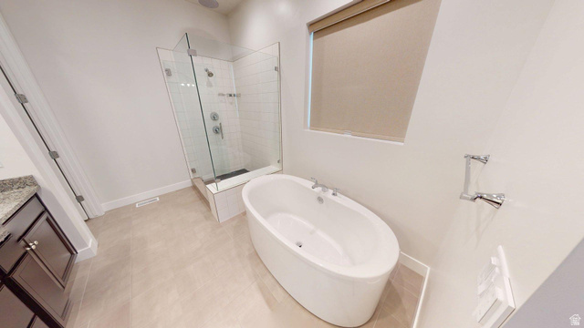 5502 North Valley View Road Lehi, UT 84048 - Photo 13 of 33 Contemporary bathroom featuring a freestanding soaking tub, frameless glass shower enclosure with subway tile surround, granite countertop vanity, and light-toned floor tiling