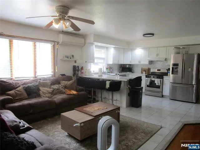 a living room with furniture a window and kitchen view