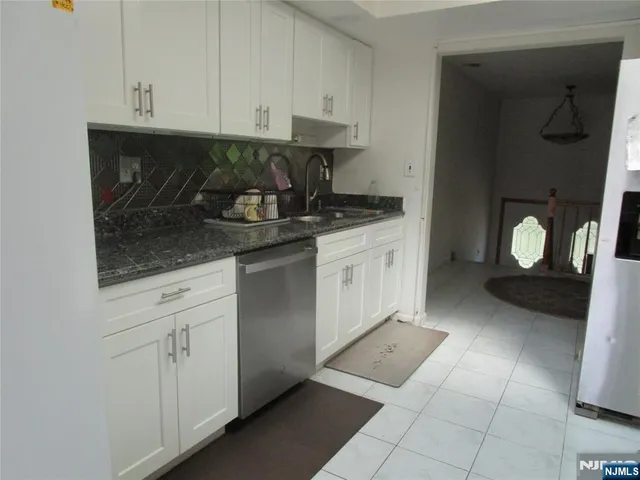 a kitchen with stainless steel appliances granite countertop a sink and cabinets