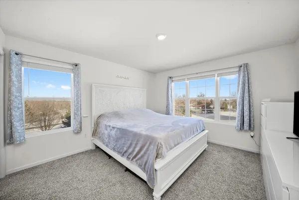a large bed sitting in a bedroom next to a window