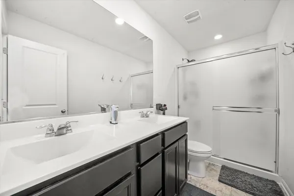 a bathroom with a sink toilet a mirror and shower