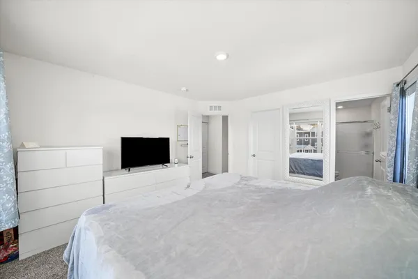 a bedroom with a bed and a flat screen tv